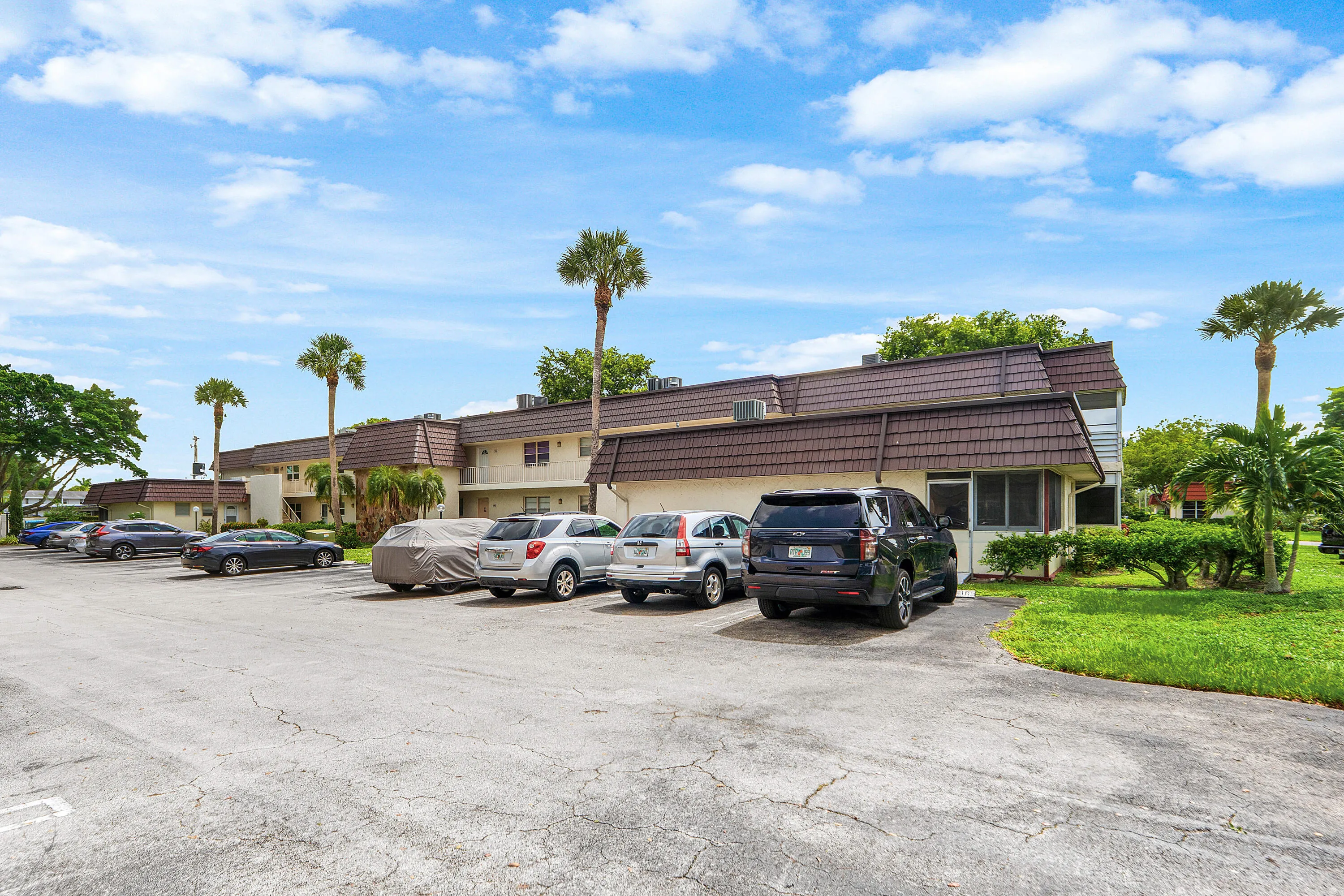 Multi-unit structure featuring a brown shingle roof and light-toned exterior