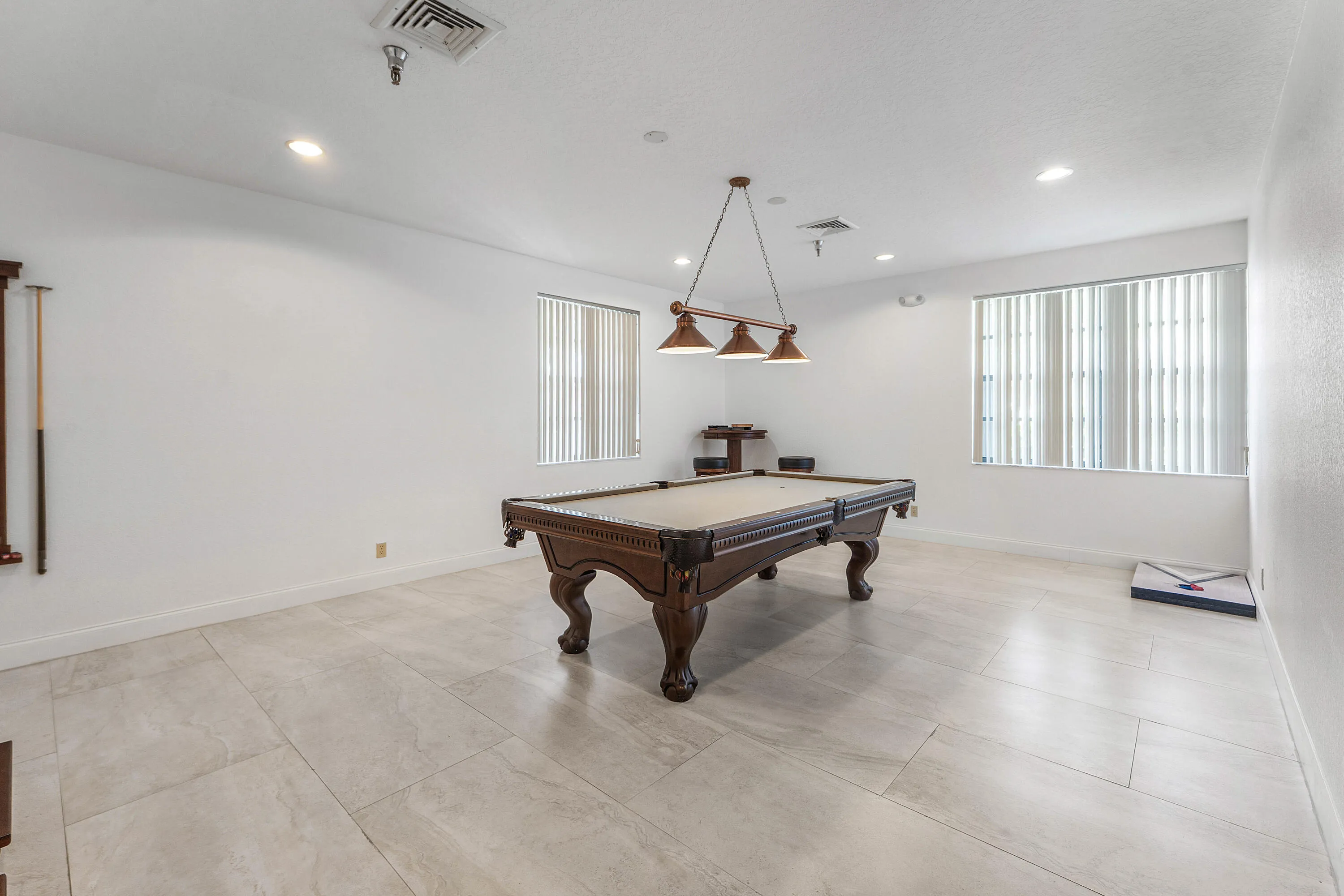 Spacious room with large format tile flooring and recessed lighting