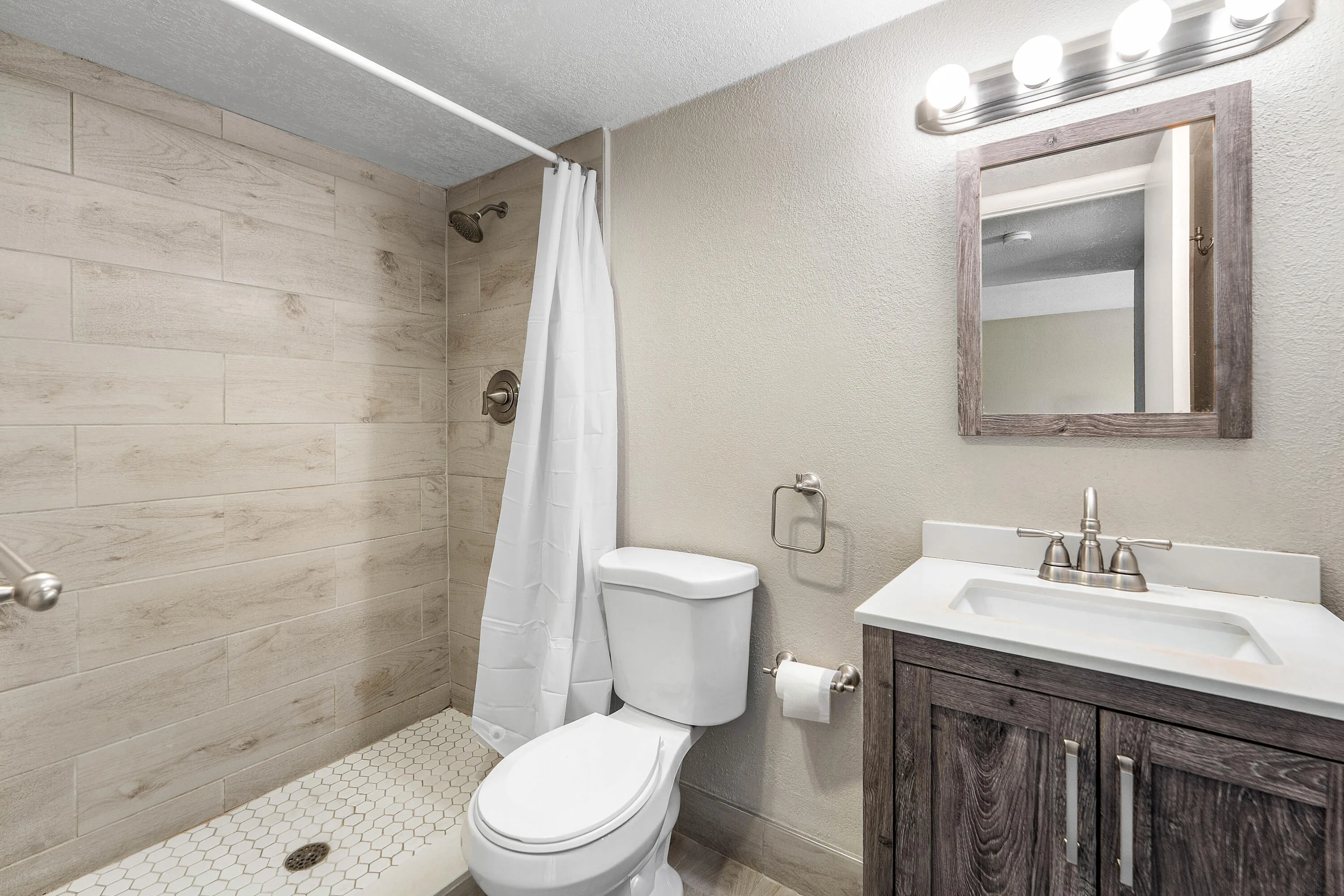 Shower featuring wood-finish tile walls and hexagonal floor tile