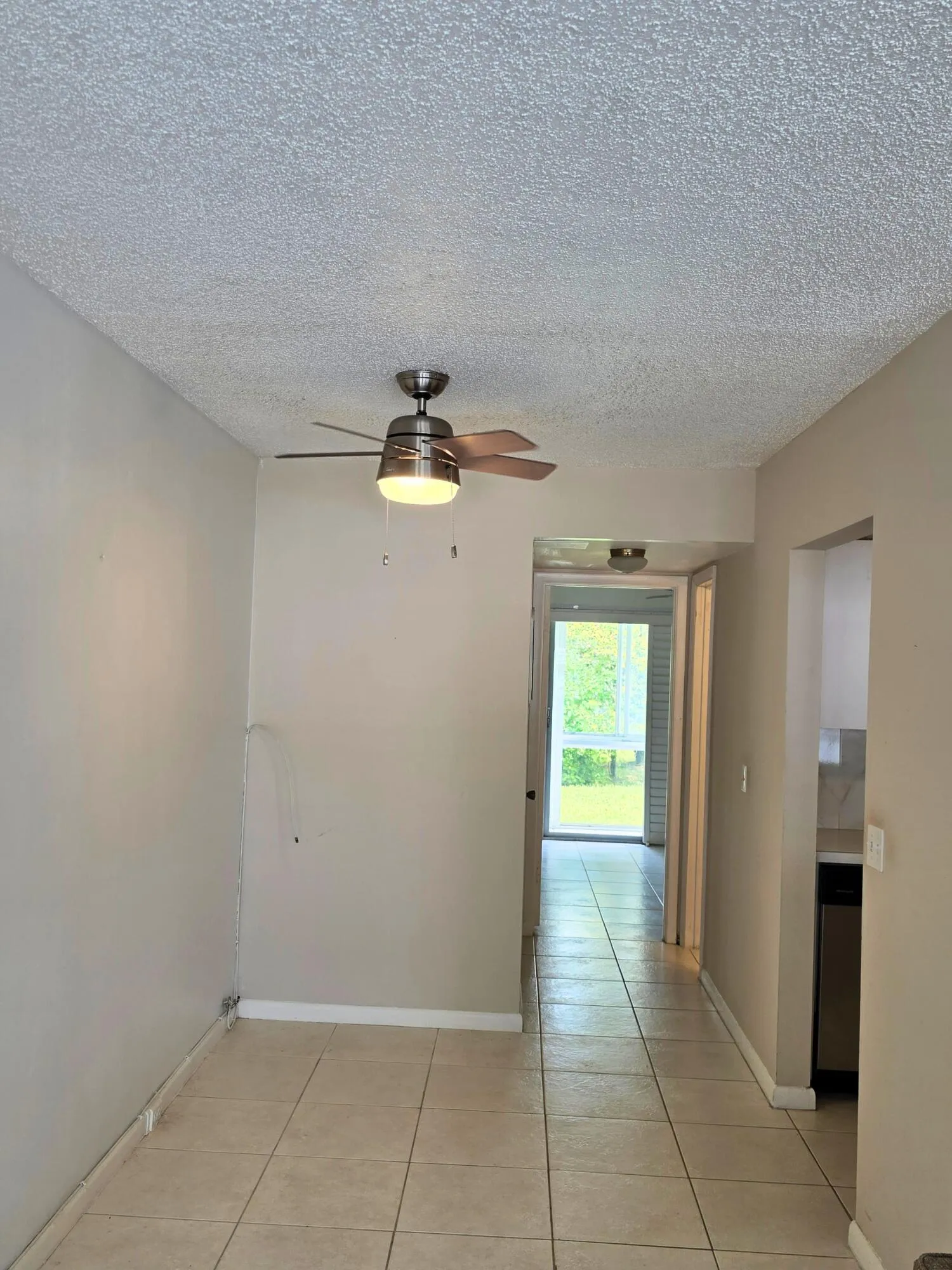Tile flooring, ceiling fan with integrated lighting, and neutral wall tones