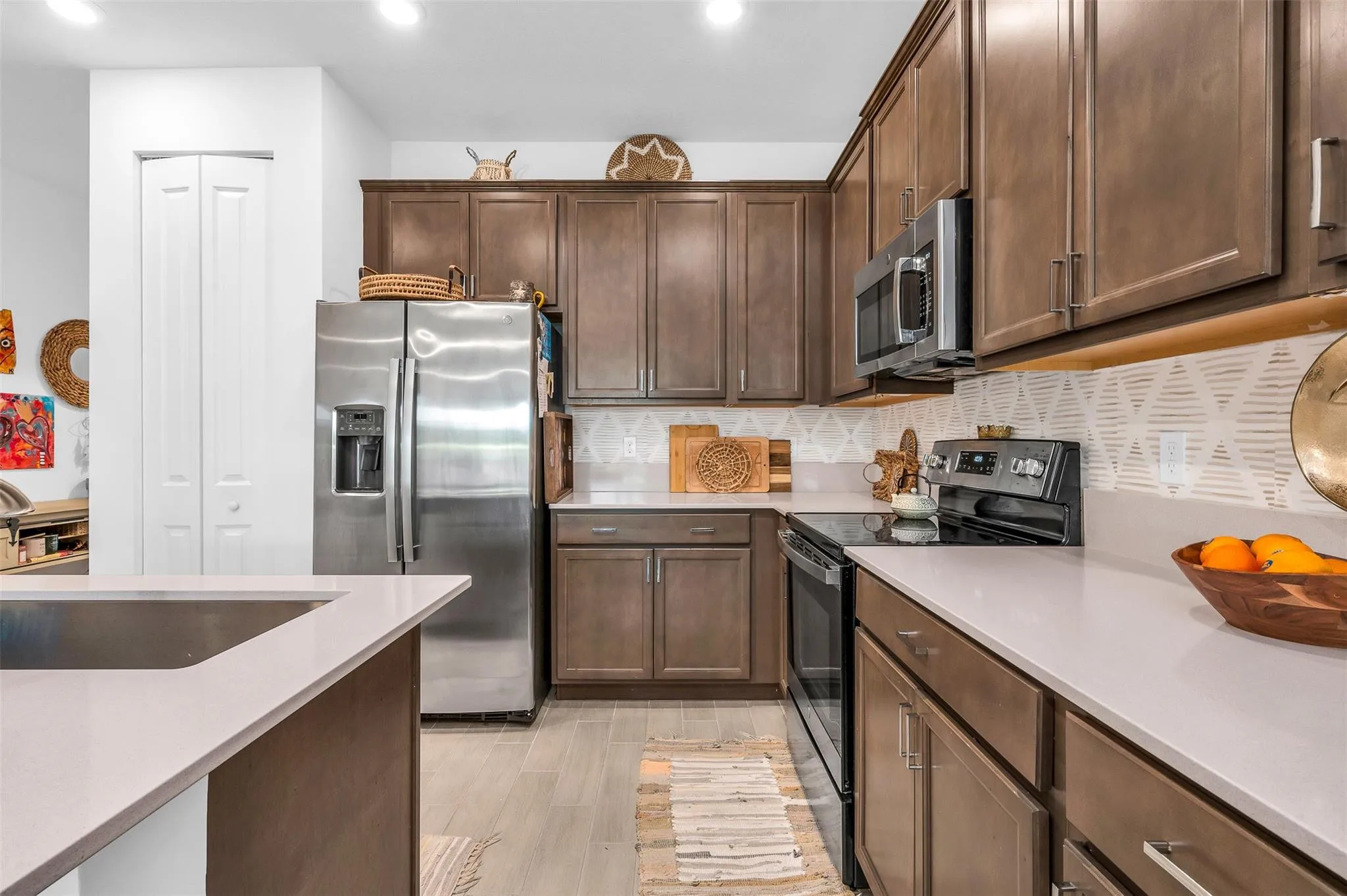 Kitchen featuring wood-finish cabinetry, stainless steel appliances, light-toned countertops