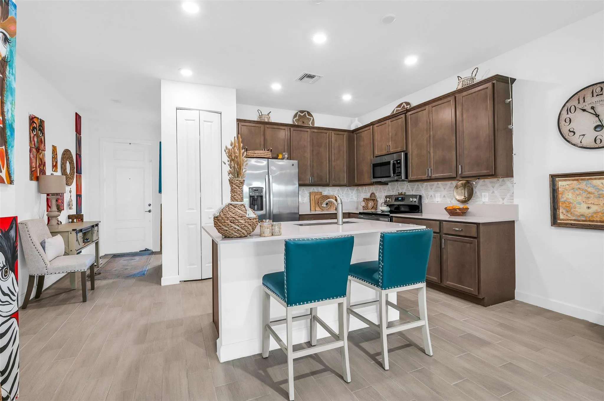 Kitchen featuring tile flooring, recessed lighting, a kitchen island with seating, wood cabinetry, and stainless steel appliances