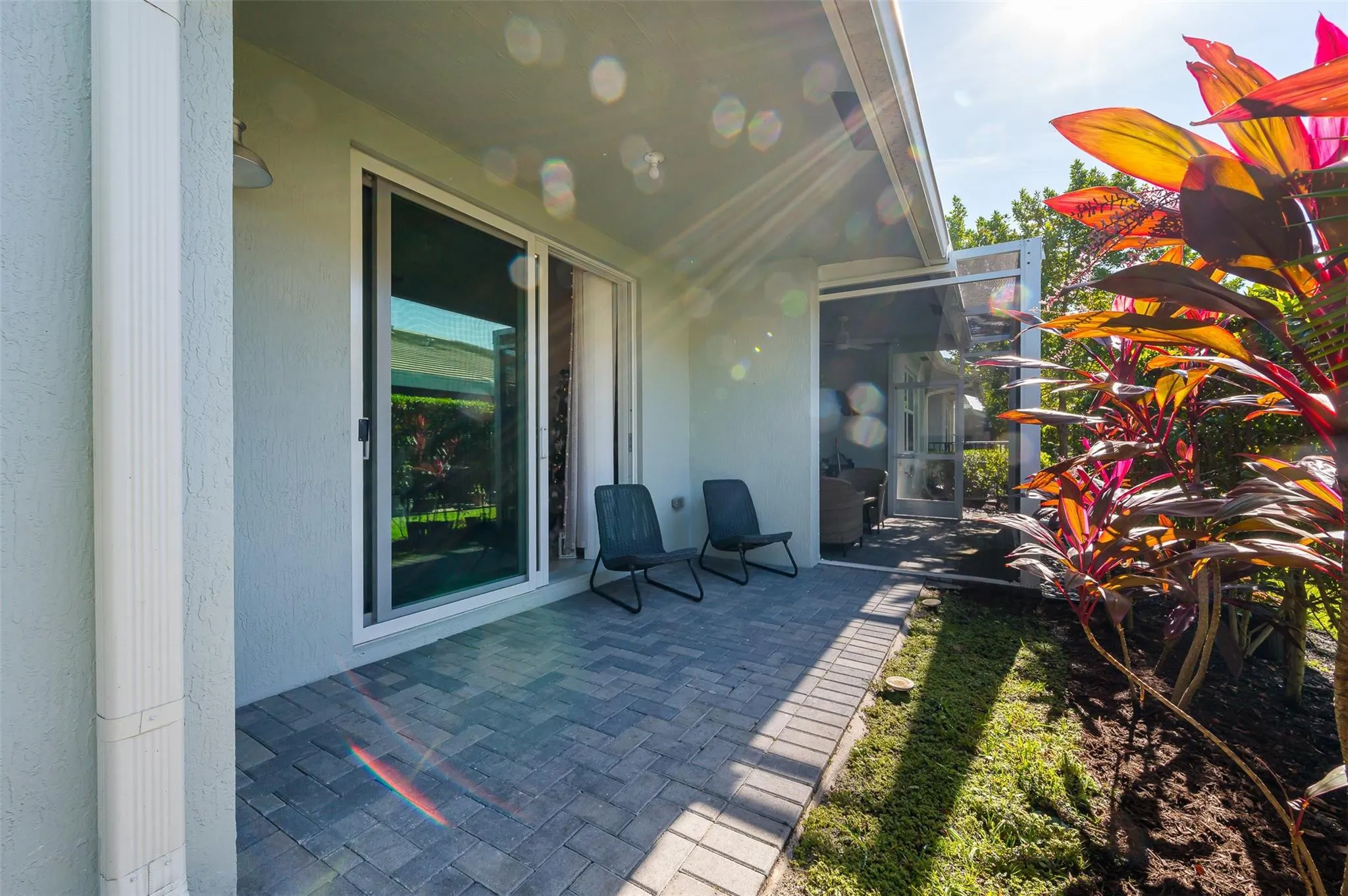 Patio featuring paver, sliding glass doors, and a screened doorway