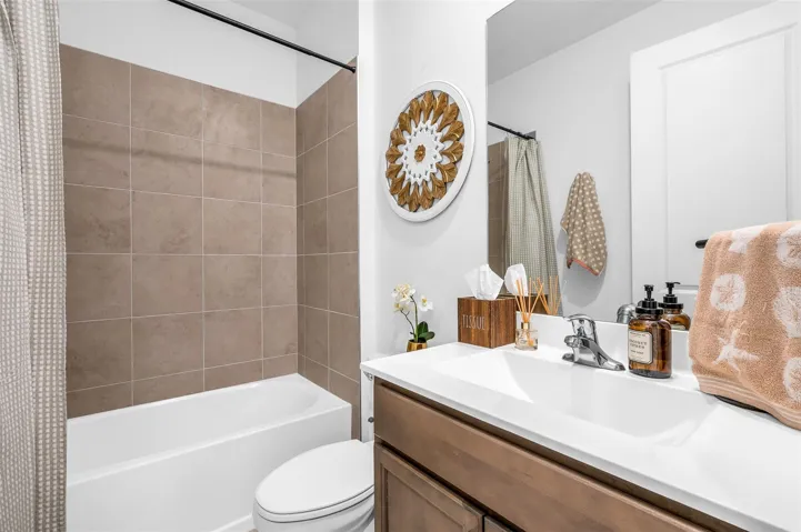 White single-basin vanity with an integrated countertop, chrome-finish faucet, and coordinating wood-finish cabinetry