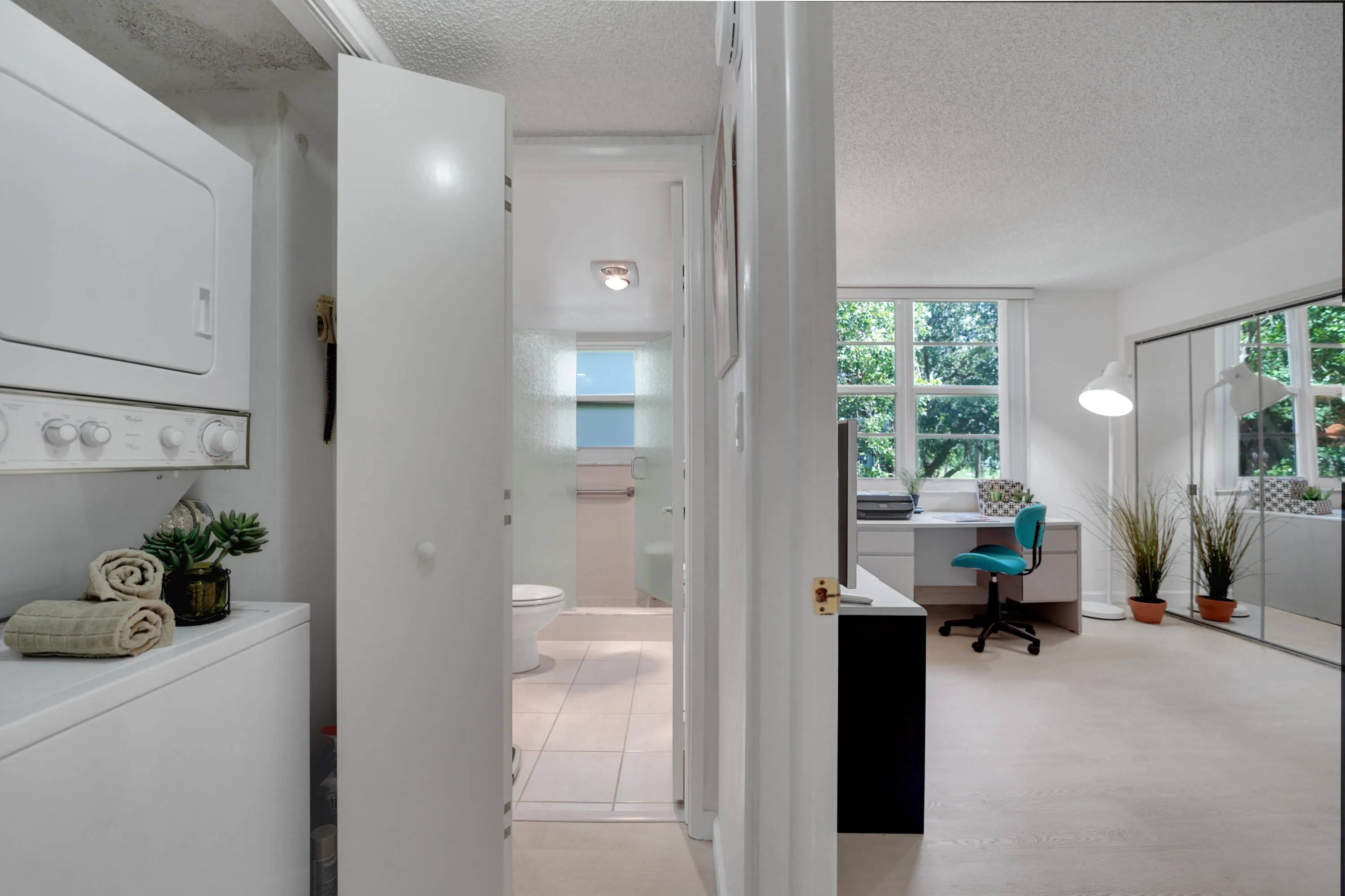 Washer-dryer next to hot water heater behind folding door leading to guest bath and 2nd bedroom