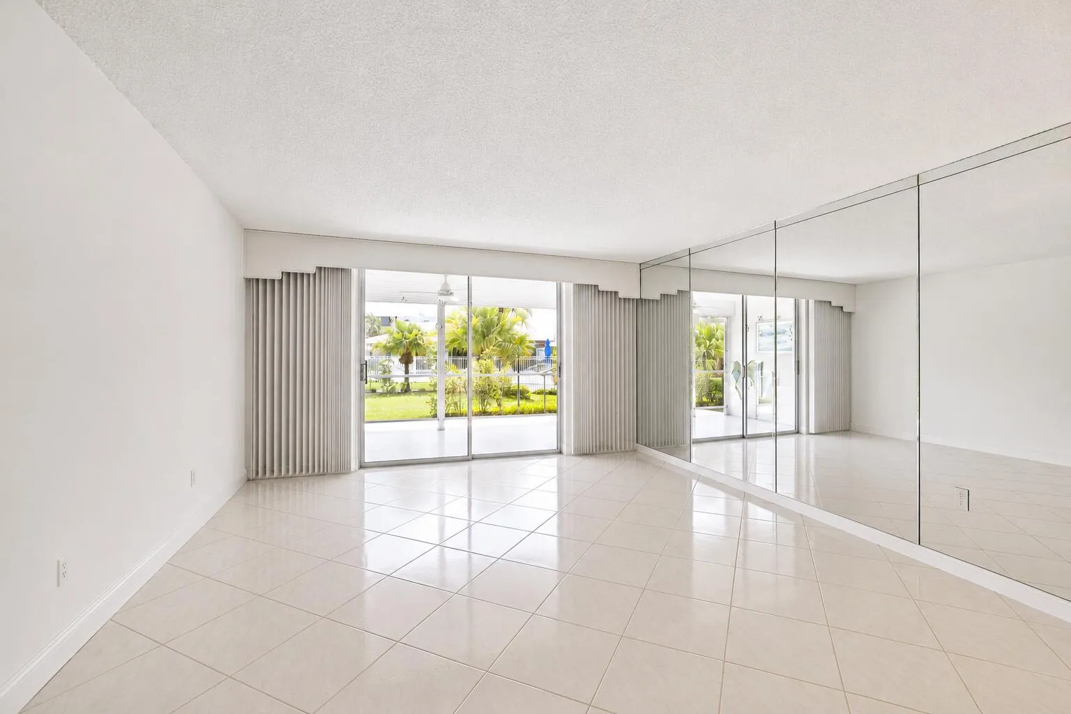 Bright, open living space flooded with natural light through expansive glass doors and windows
