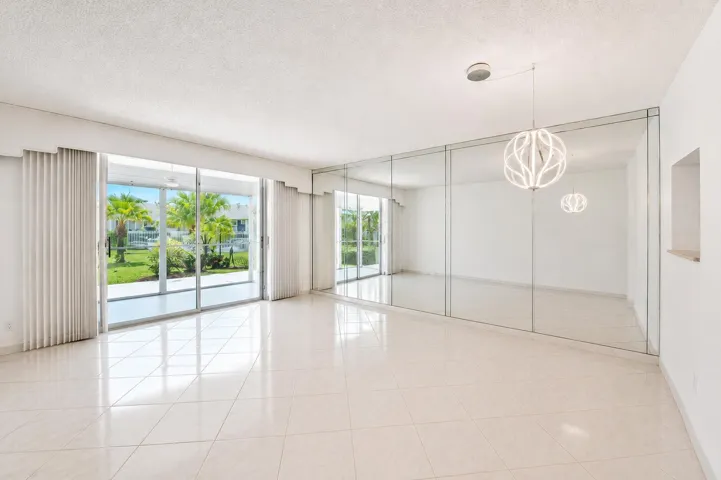 Spacious interior featuring large format tile flooring and a mirrored accent wall