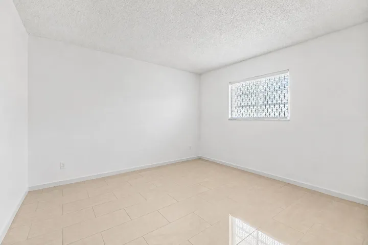 Bright, light-filled room featuring ceramic tile flooring, and clean white walls