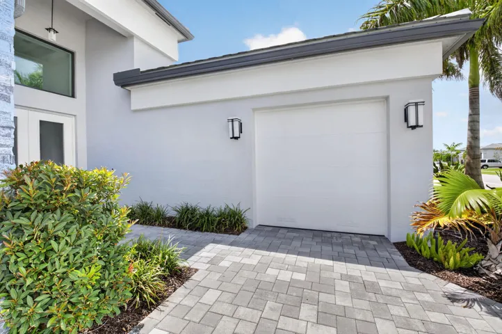 Two contemporary impact-rated garage doors with impact windows and doors throughout