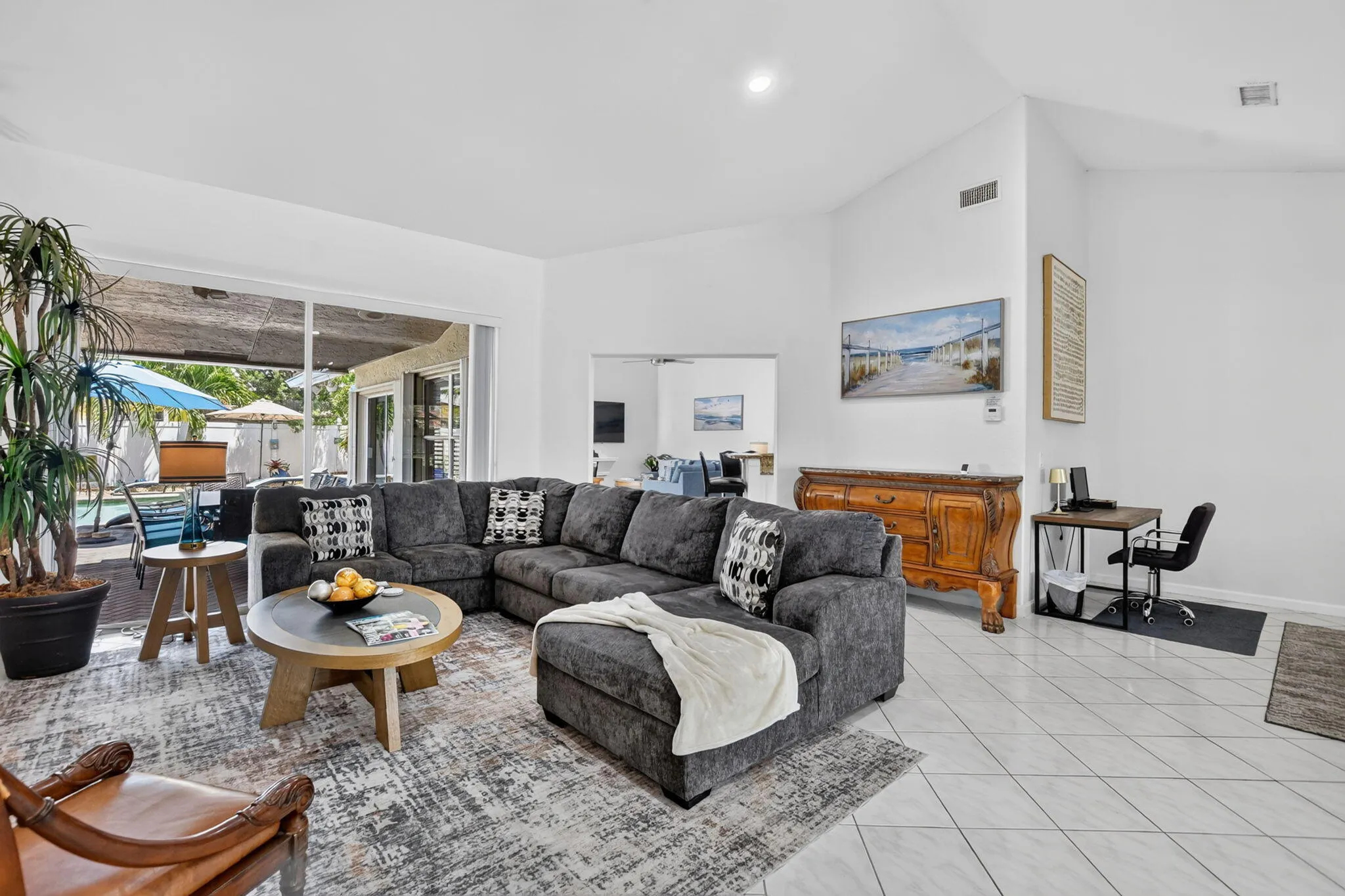 Vaulted ceiling, white tile flooring, sliding glass door, and recessed lighting