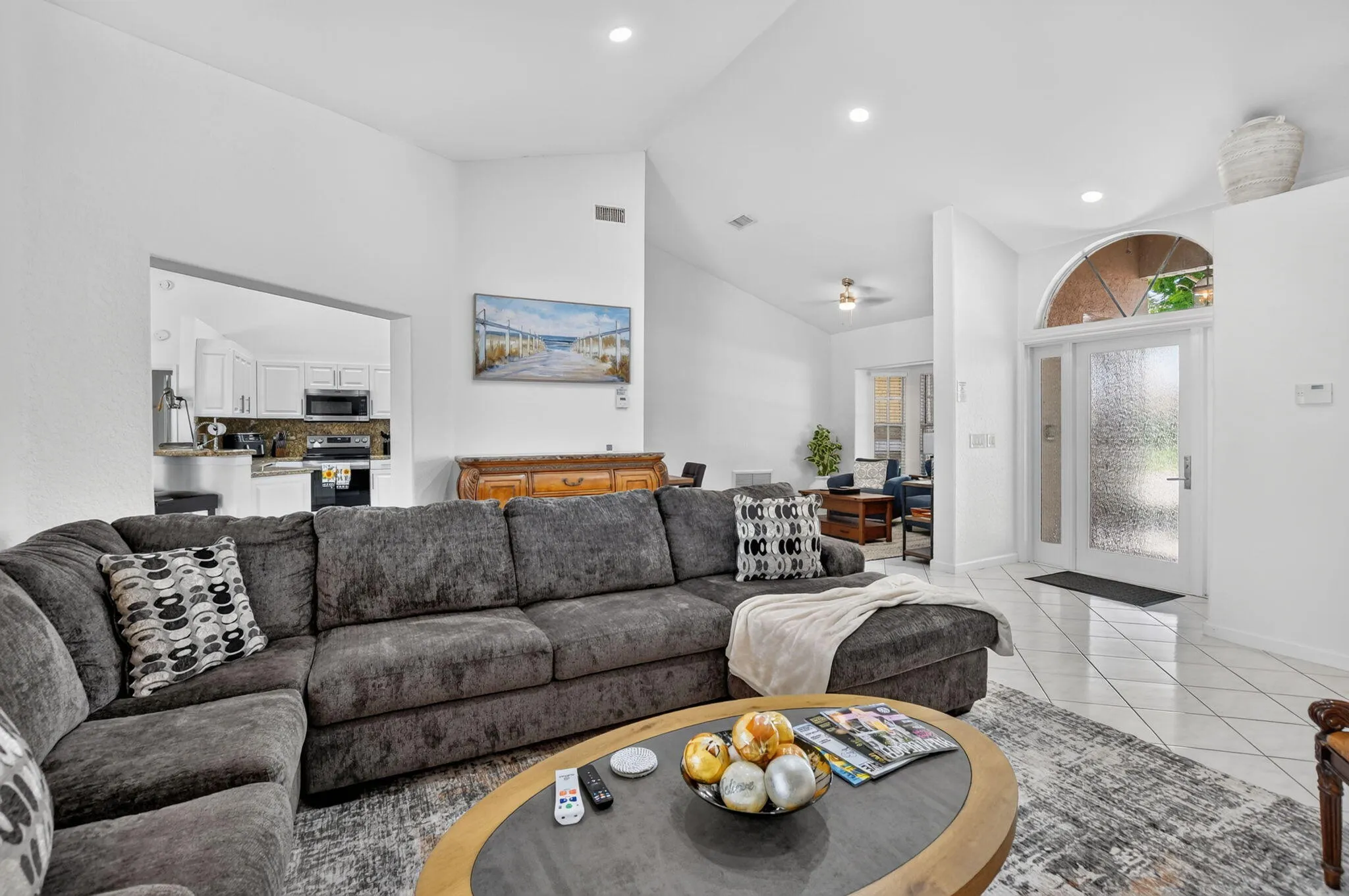 Vaulted ceilings, recessed lighting, and a kitchen pass-through
