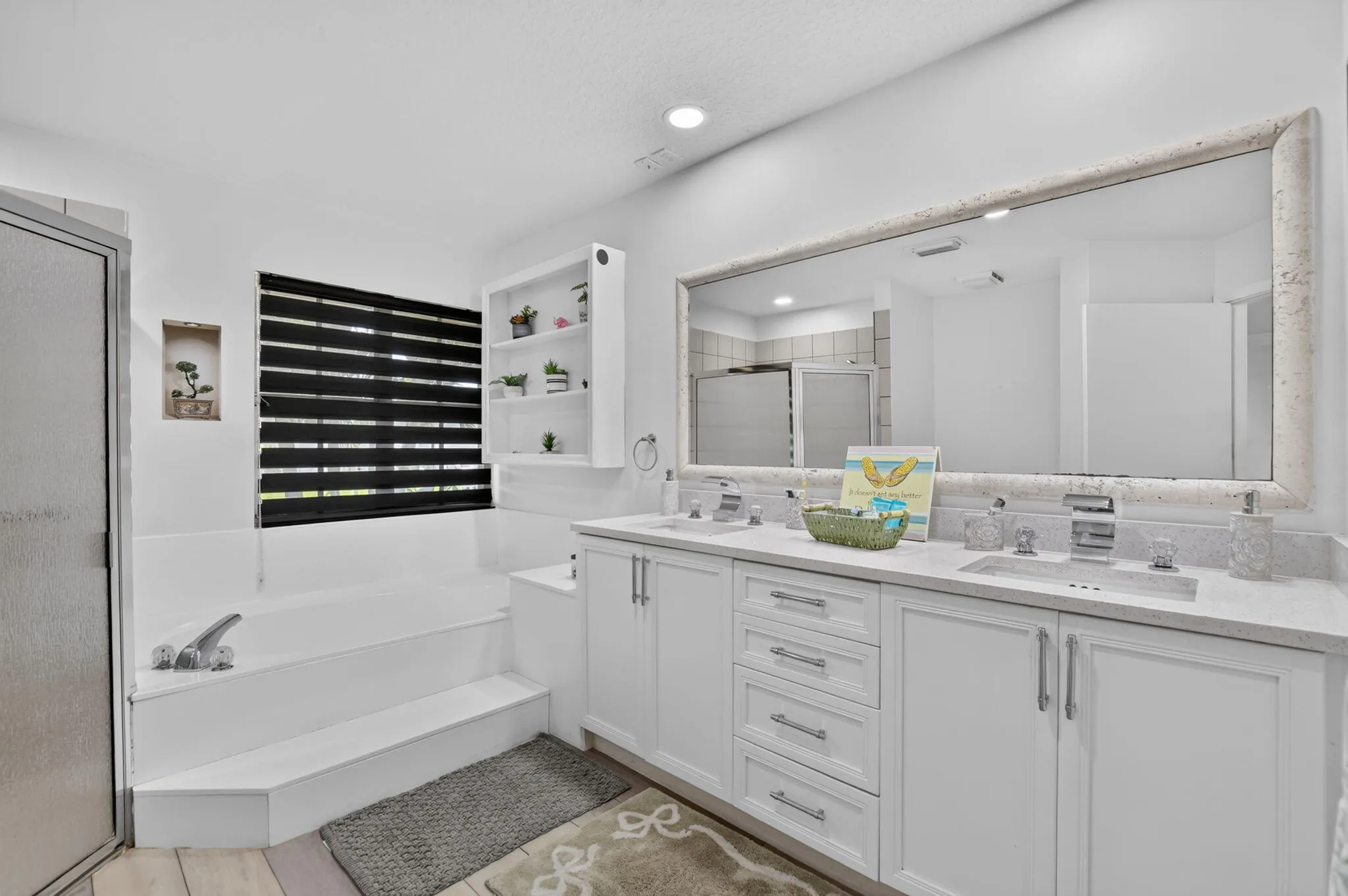 White double vanity with integrated sinks, light-toned countertop, and silver-tone fixtures