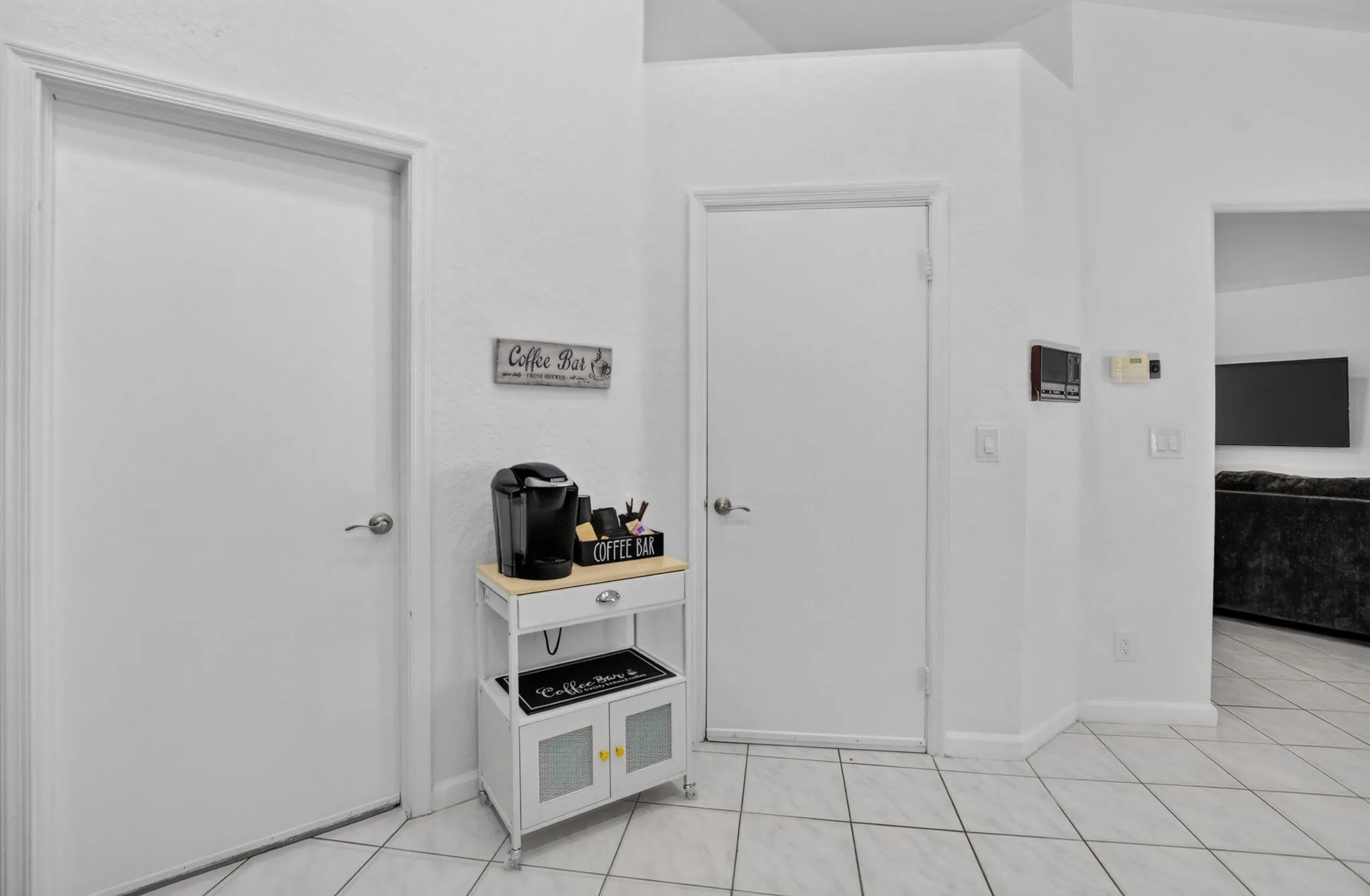 Light-toned tiled flooring, white walls, and bright white interior doors