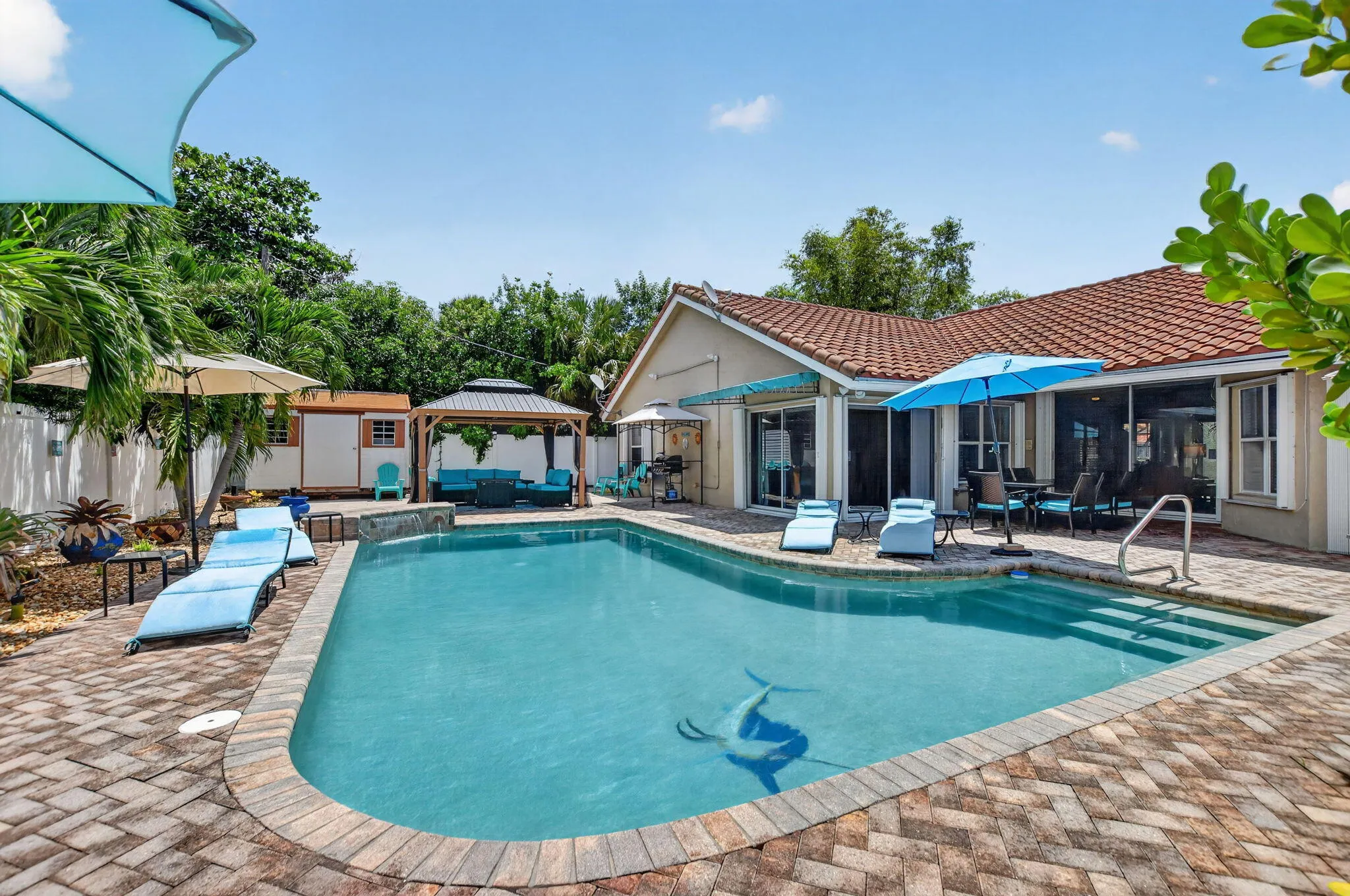 Tiled-roof residence with a spacious swimming pool featuring an inlaid tile design