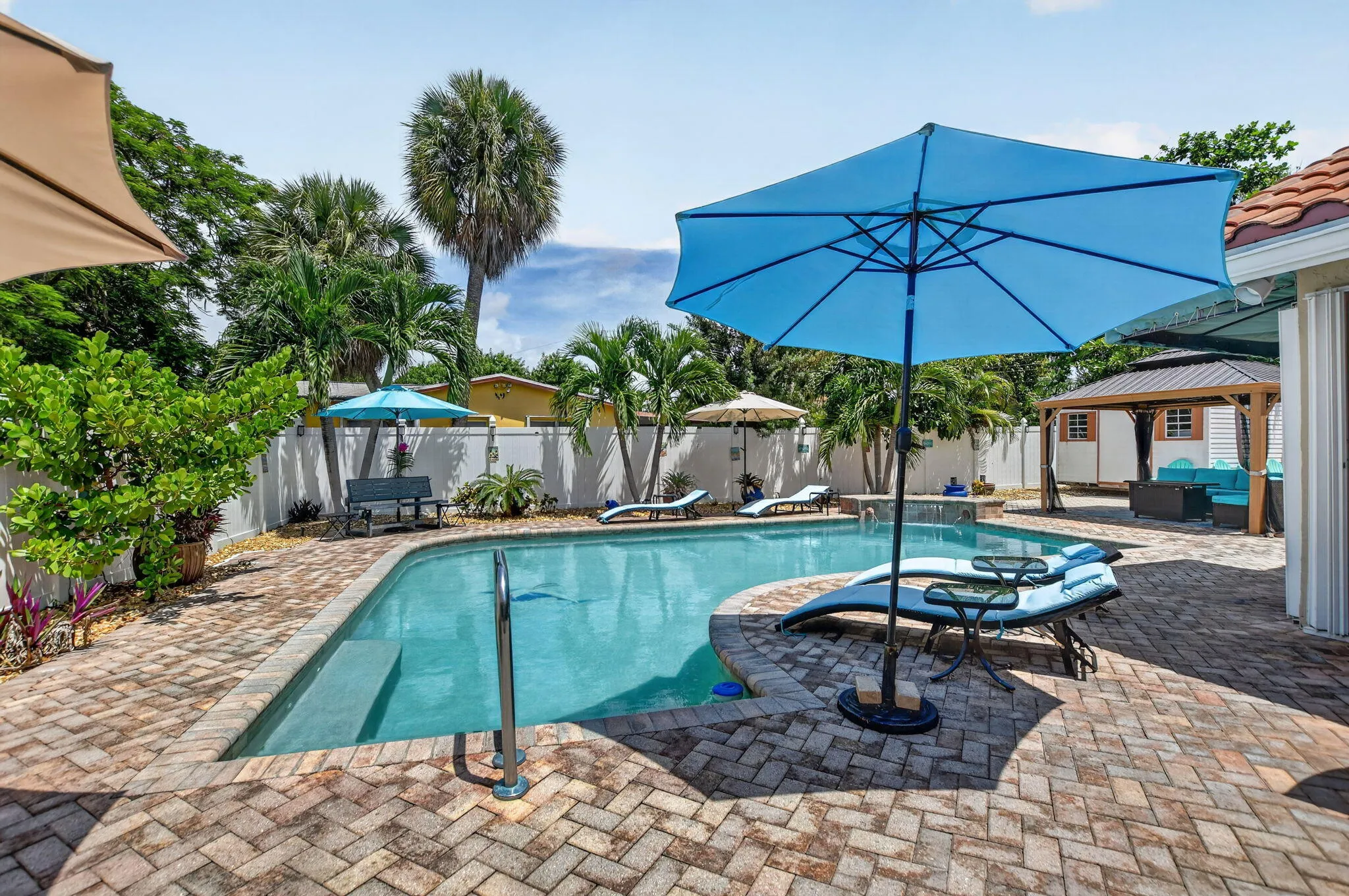 Swimming pool with curved edges, surrounded by a paver patio