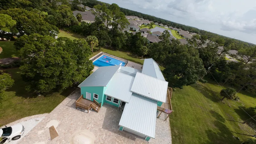 Aqua exterior home featuring multiple decks, a metal roof, and a private pool