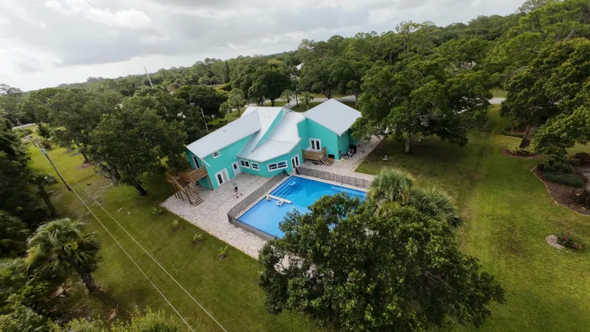 Contemporary residence with a vibrant turquoise exterior and a white metal roof