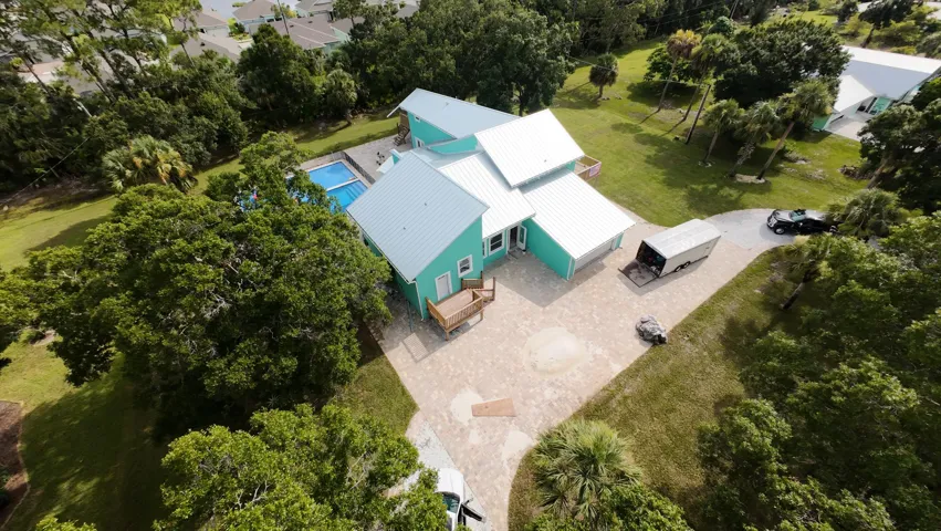Contemporary exterior featuring a turquoise facade and white metal roof