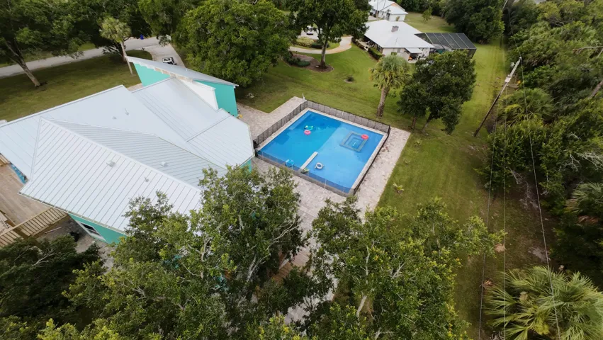 Modern residence featuring a light-colored metal roof and a turquoise exterior accent