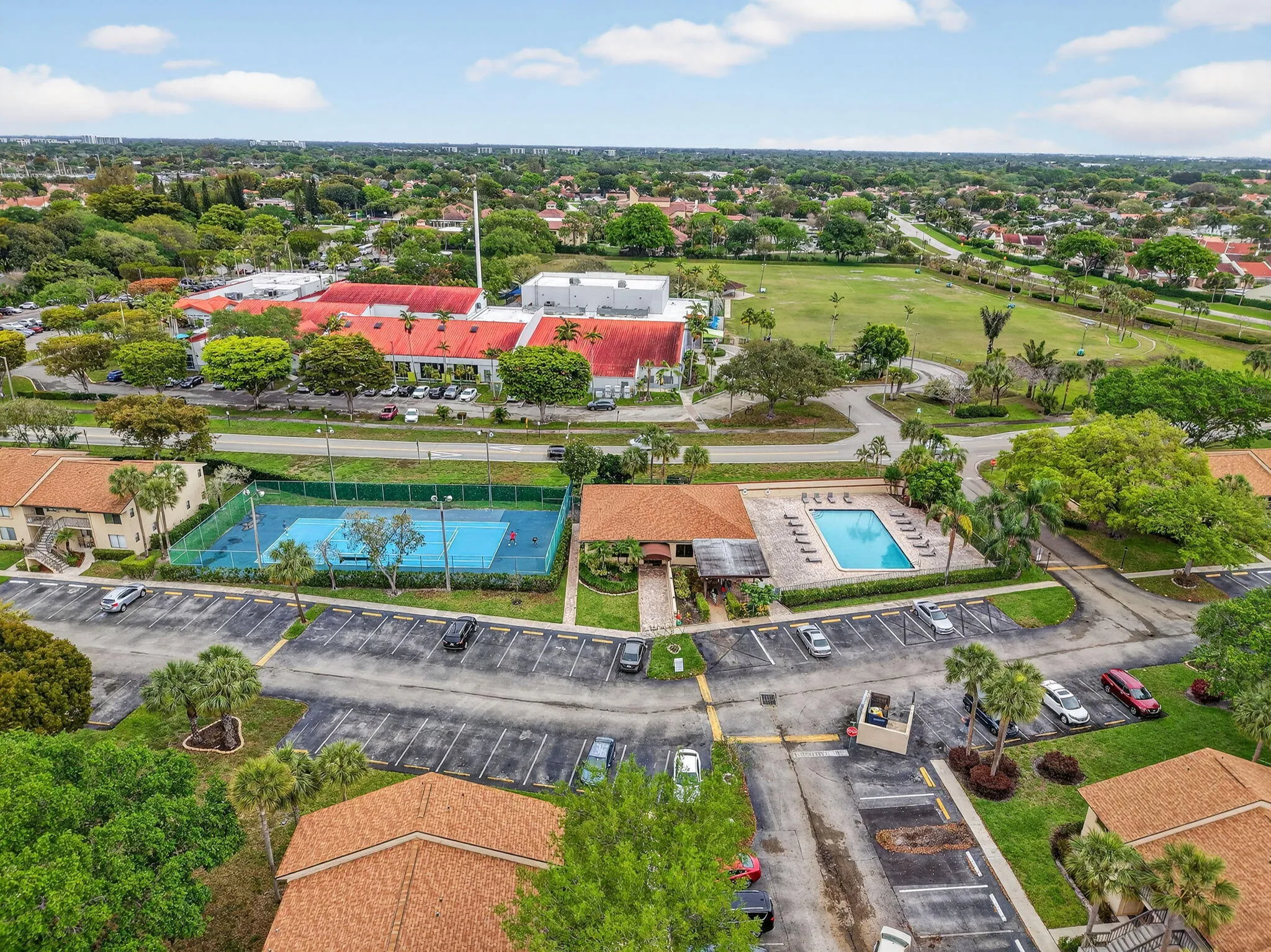 Community amenities featuring a tennis court, swimming pool, and dedicated parking areas