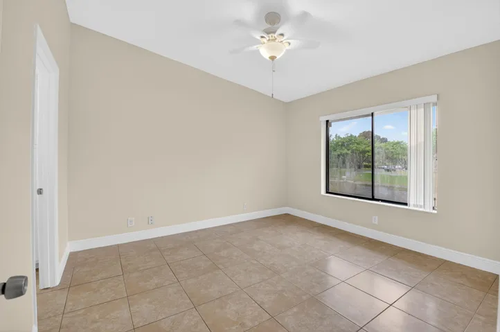 Spacious room featuring tile flooring, neutral wall finishes, and abundant natural light from large sliding glass doors with water views