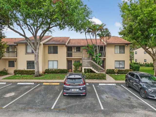 Two-story multi-unit structure featuring a neutral exterior, balconies, and a central outdoor staircase