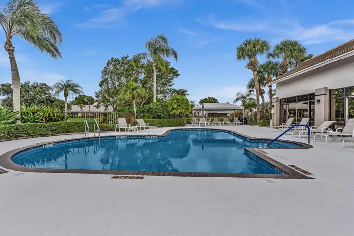 Freeform swimming pool with integrated spa, surrounded by a paved deck