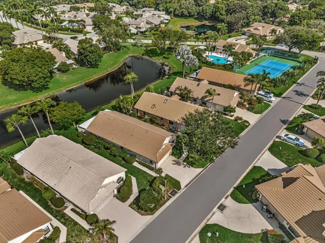Residential community with multiple residences, a tennis court, swimming pool, and a pond