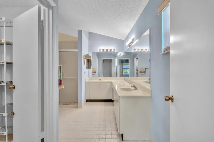 Dual vanity with undermount sinks, integrated countertop, and wall-mounted lighting