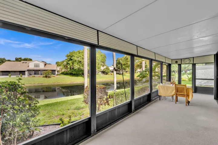 Enclosed patio with full-height windows, carpeted flooring, and a flat ceiling