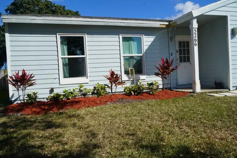 light blue siding with white trim, and landscaping.
