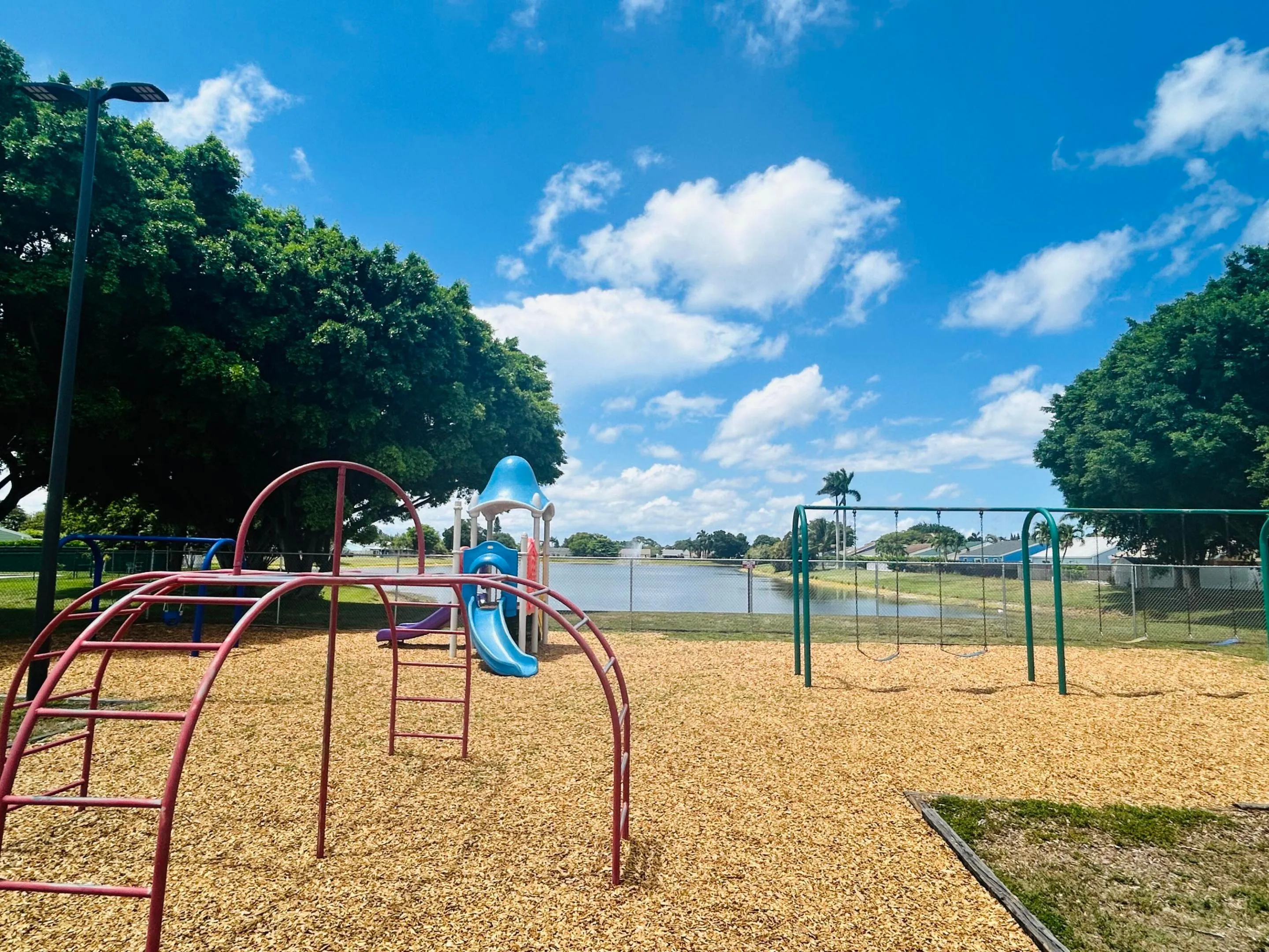 Playground featuring a slide, climbing dome, and swings