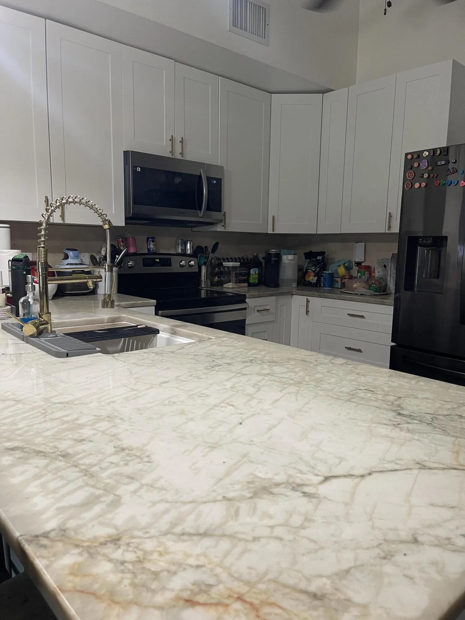Beautiful kitchen touches in handles, faucet, and countertop.