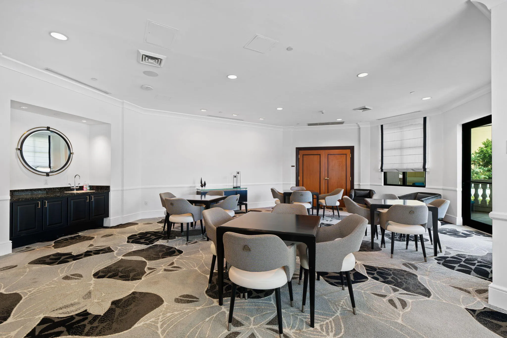 Resident card room with multiple game tables, lounge seating & a wet bar for casual gatherings.