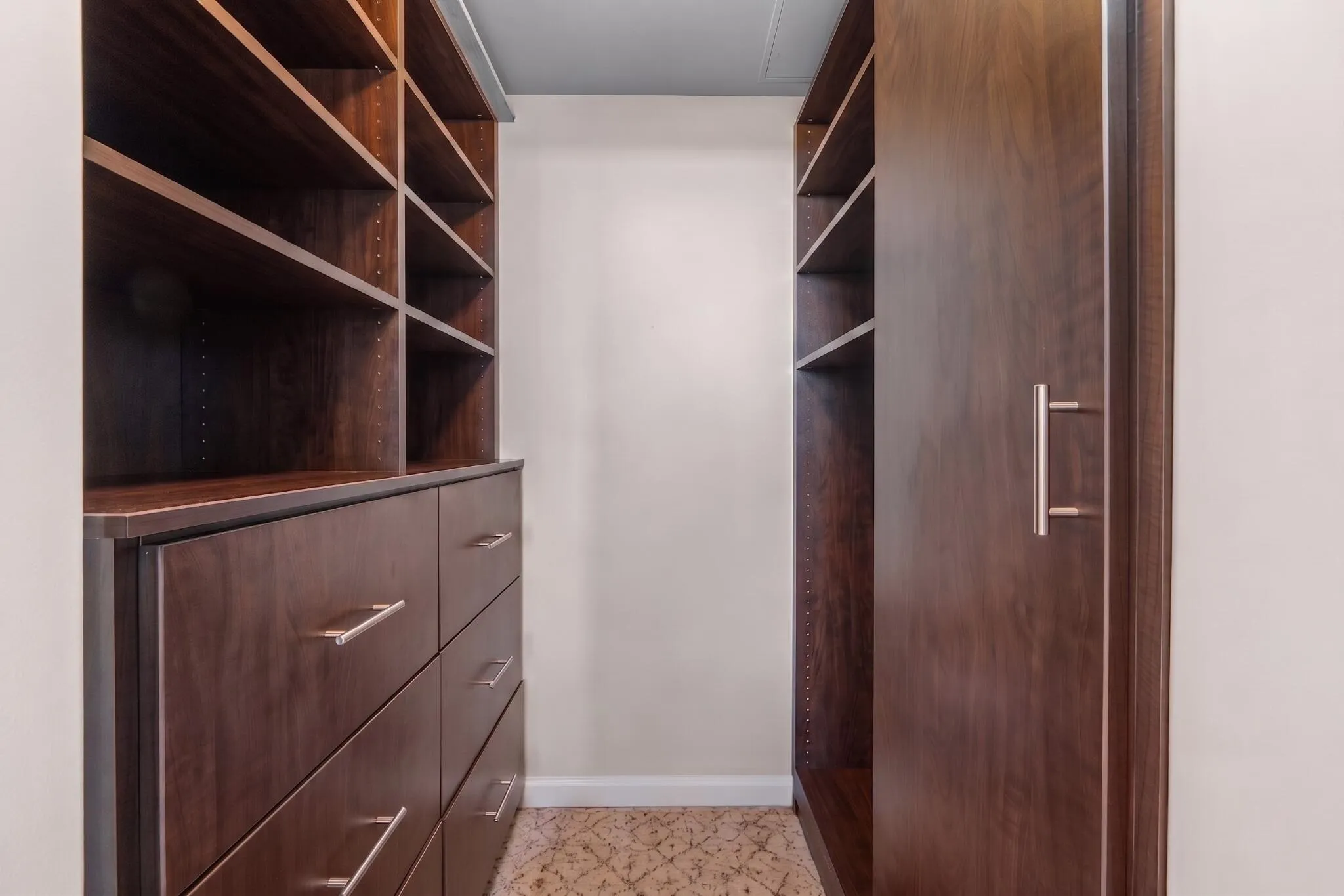 Custom walk-in closet with extensive built-in shelving, drawers & hanging storage for organized everyday living.