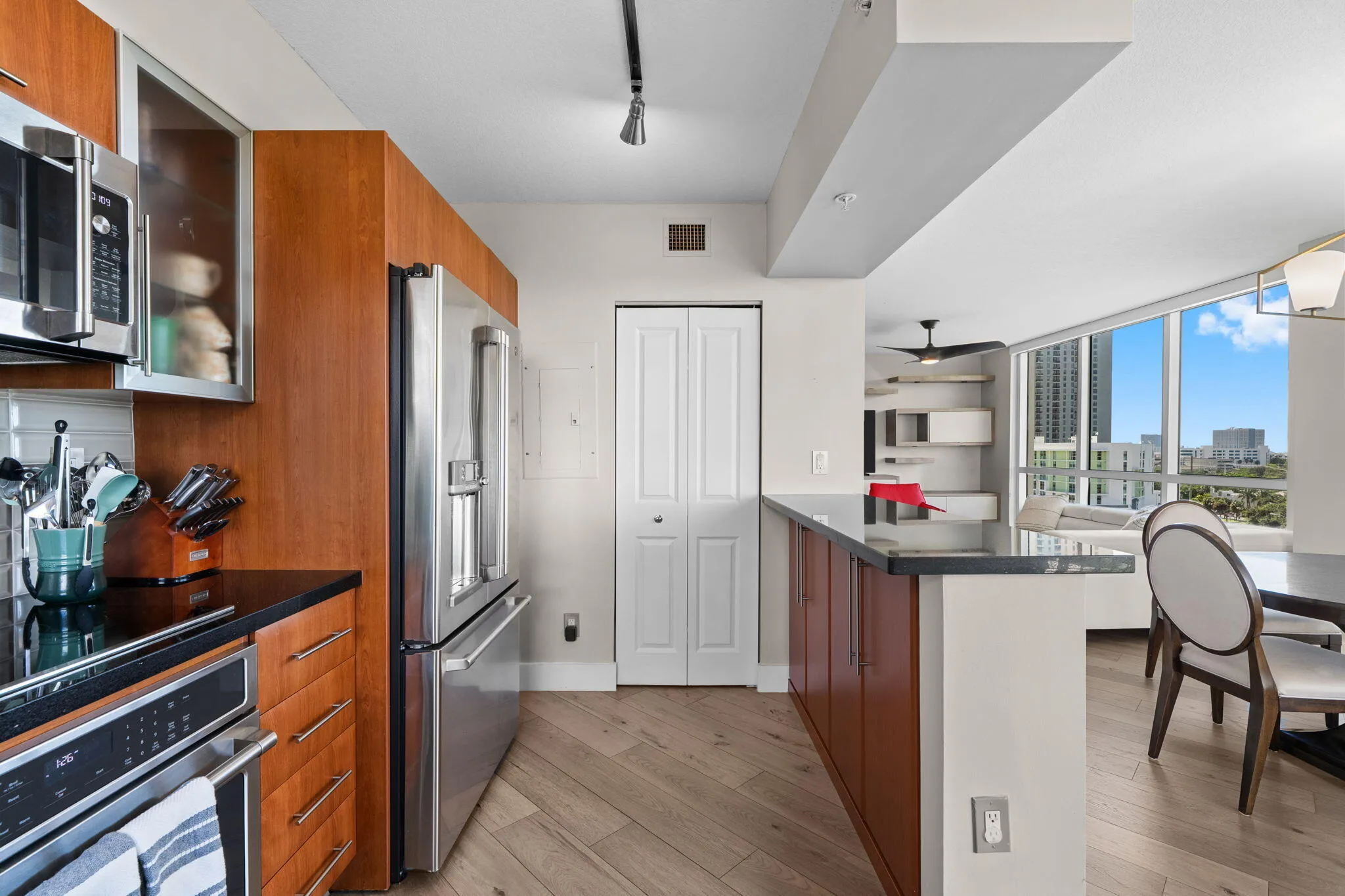 Open kitchen with breakfast counter, granite countertops & sightlines through the dining and living areas toward the surrounding views.