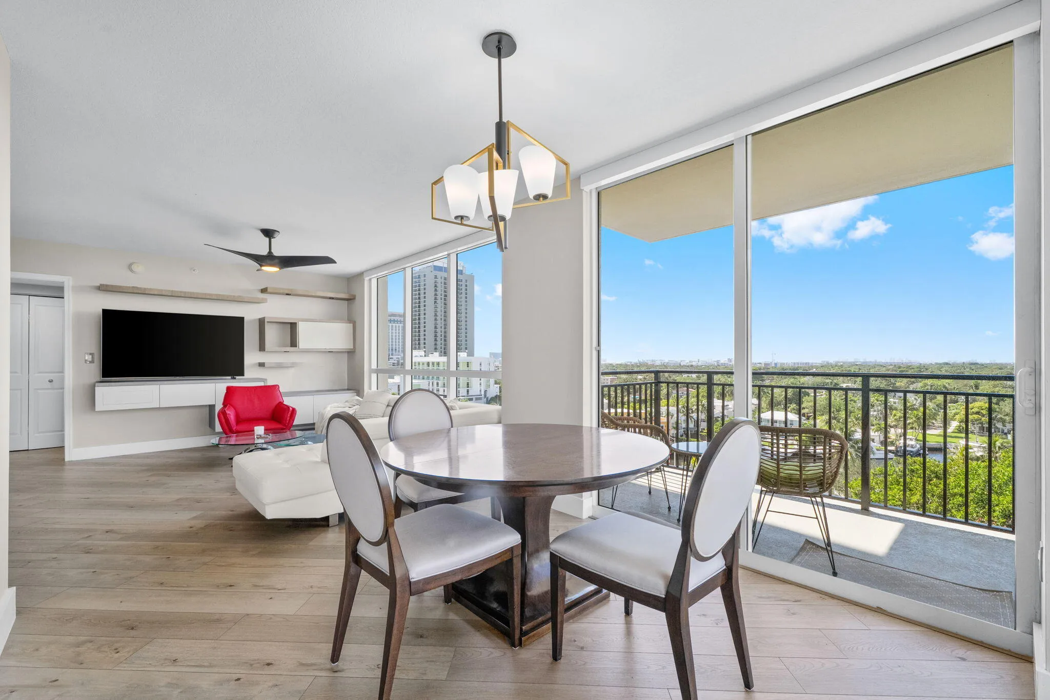 Dining area set beside expansive sliding glass doors, creating a seamless indoor-outdoor connection to the wraparound terrace and surrounding views.