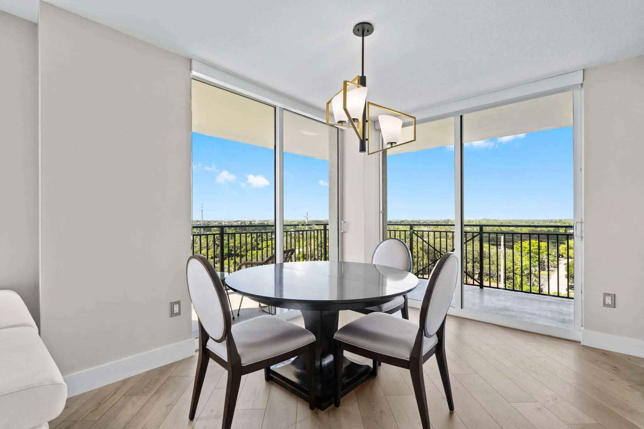 Bright dining area surrounded by glass, with direct terrace access and open views across Sailboat Bend and the surrounding Fort Lauderdale area.