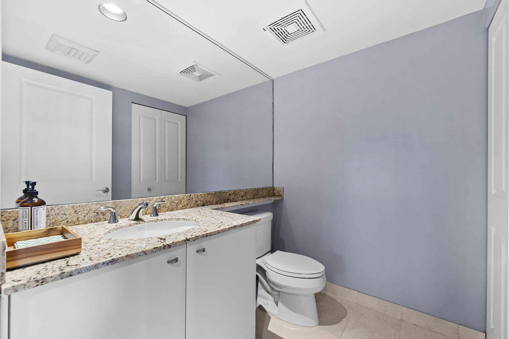 Convenient powder room with granite vanity off the foyer.