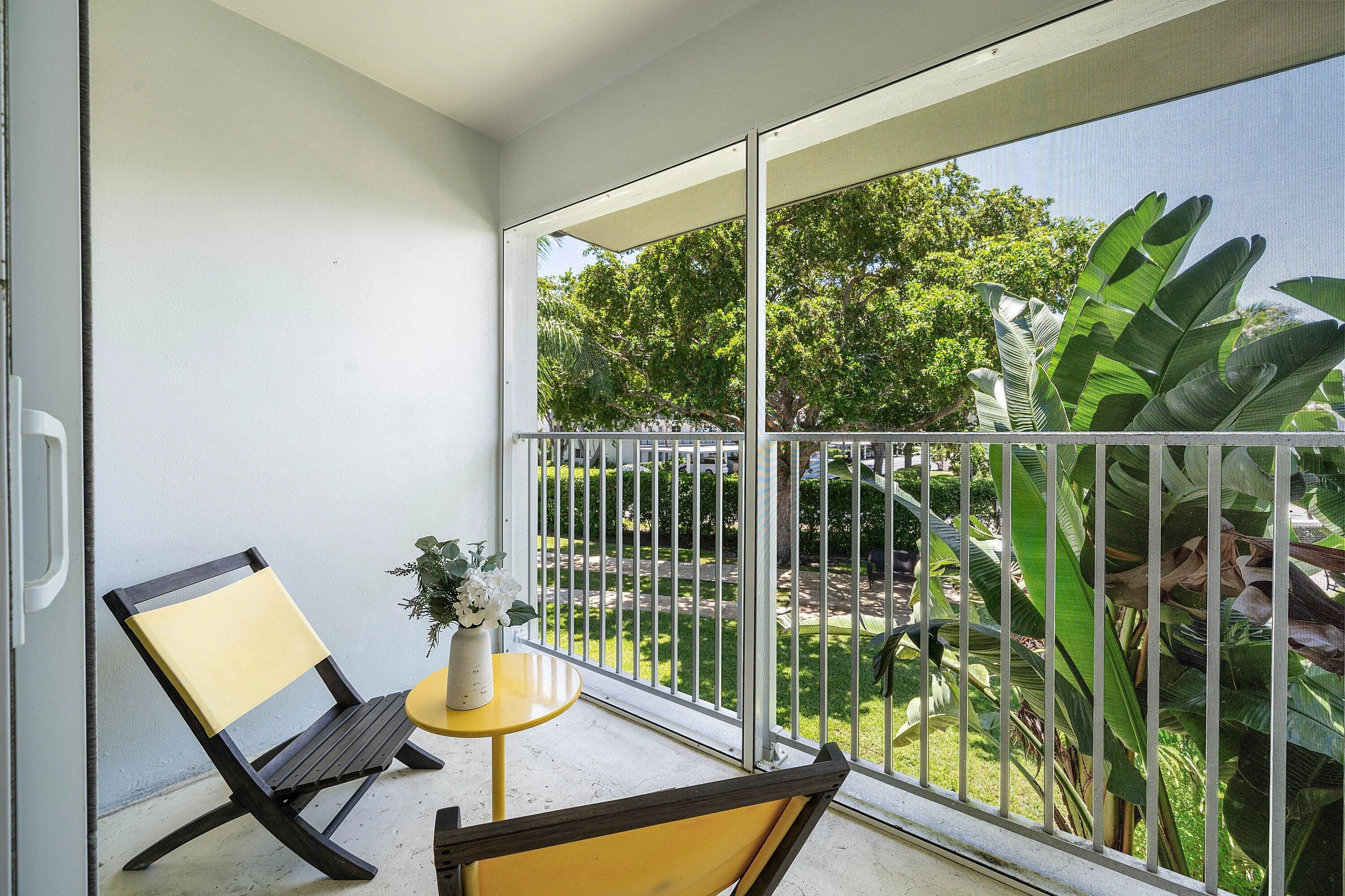 Screened balcony featuring concrete flooring and a white wall