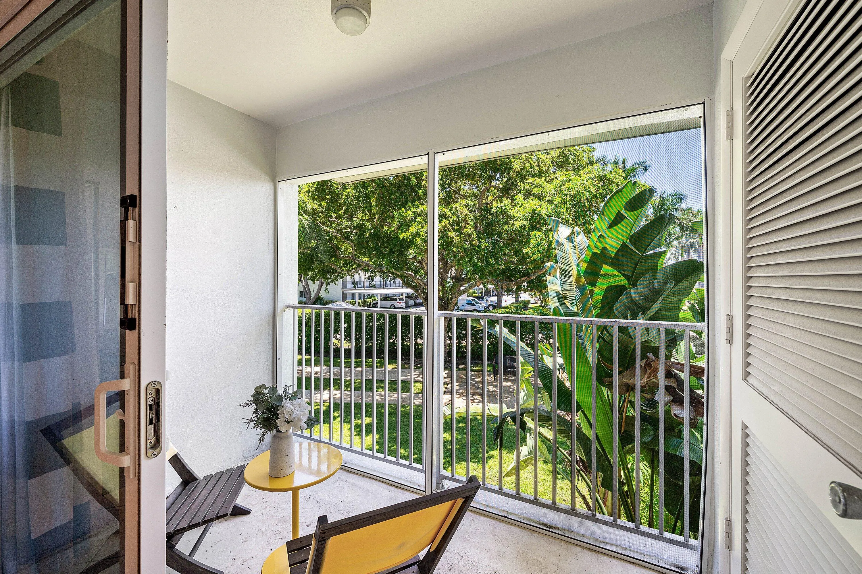 Screened balcony featuring a sliding glass door and louvered storage