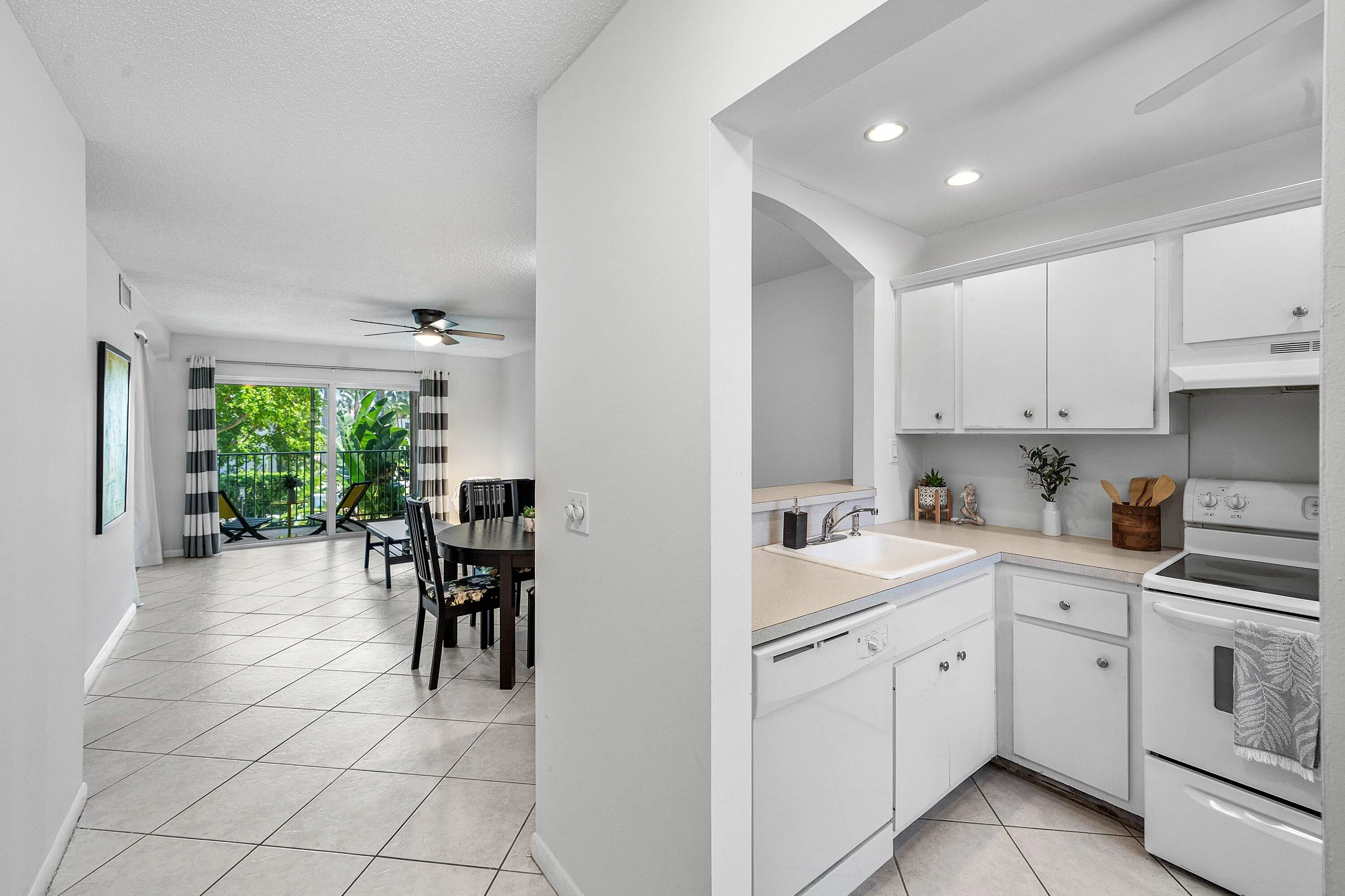 White cabinetry in the kitchen with a built-in dishwasher and recessed lighting