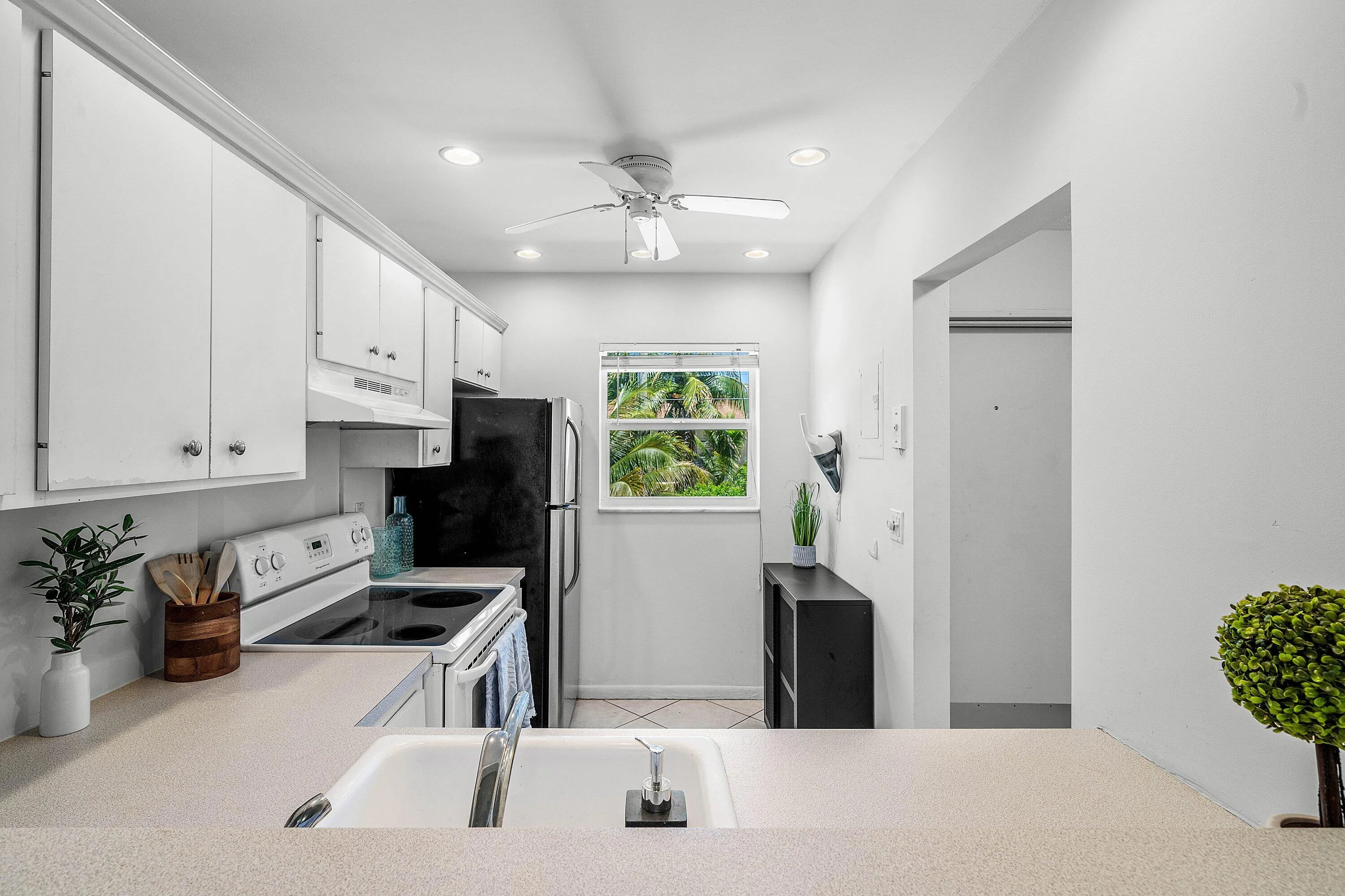 Kitchen featuring white cabinetry, recessed lighting, ceiling fan, and window