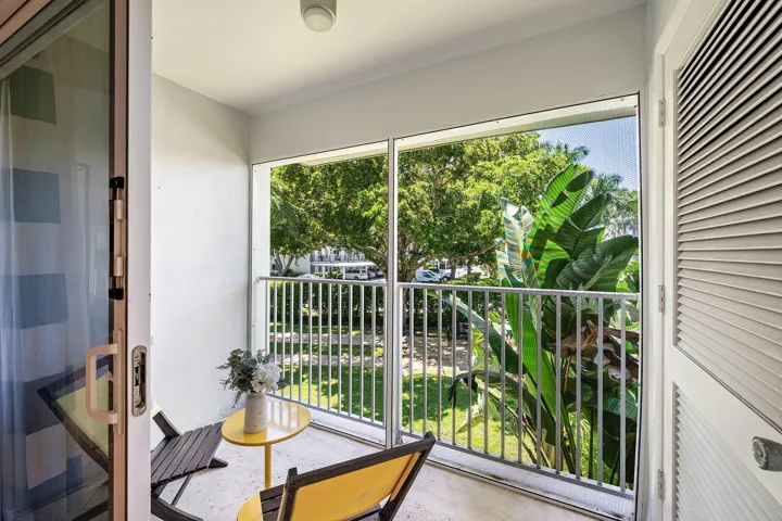 Screened balcony featuring a sliding glass door and louvered storage