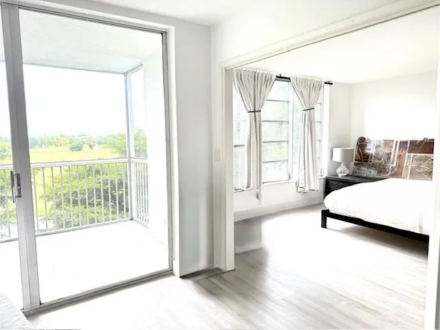 Sliding glass doors opening to a private screened balcony with white railings