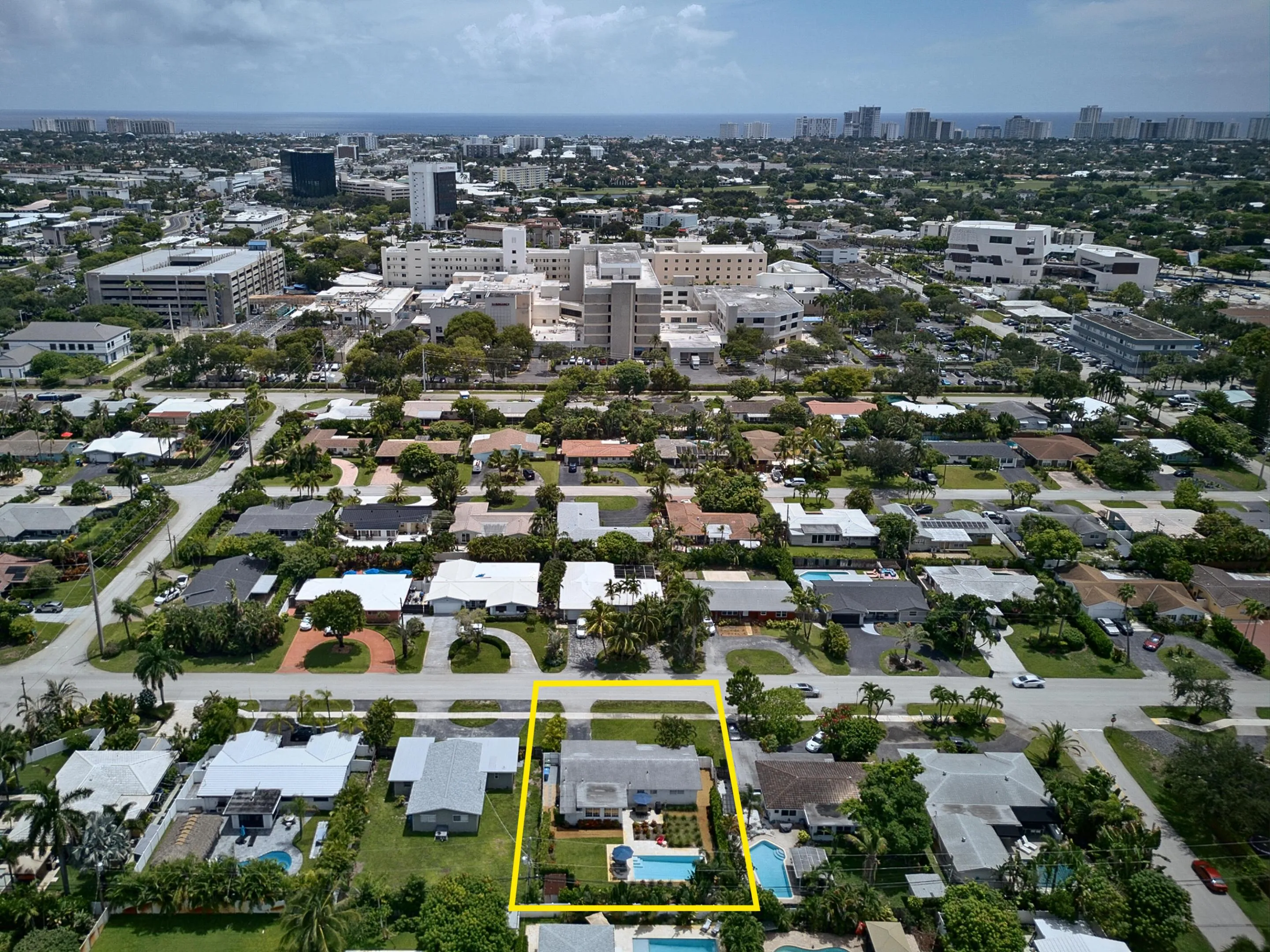 Aerial view showcasing an expansive lot with mature landscaping, resort-style swimming pool, and manicured grounds