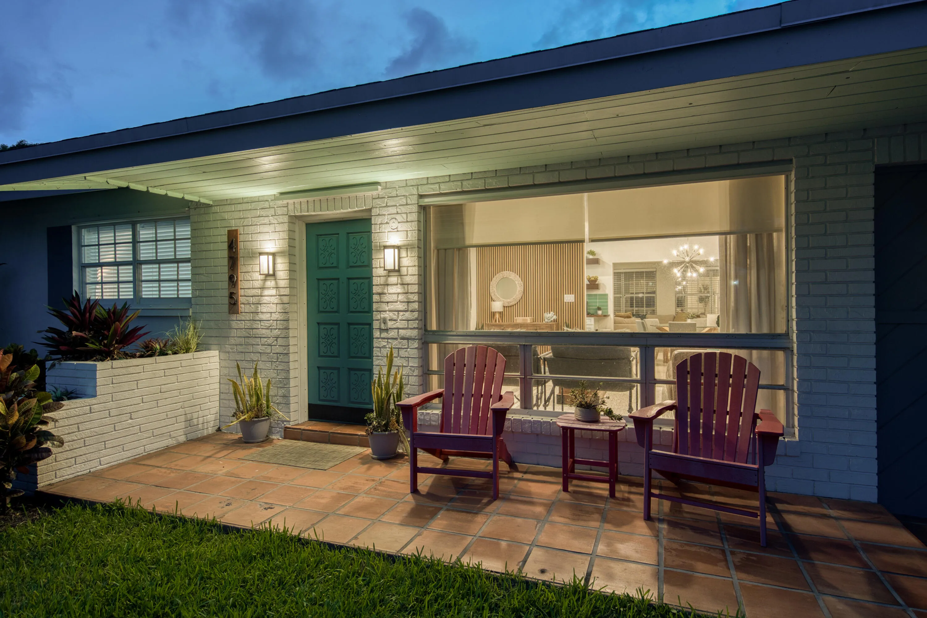 White brick exterior with a teal entry door