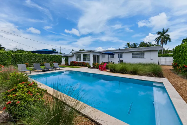 Rectangular in-ground swimming pool with light-toned coping, surrounded by gravel pathways and mature landscaping