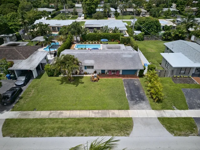 Expansive lawn with mature landscaping, a private swimming pool, and asphalt driveway