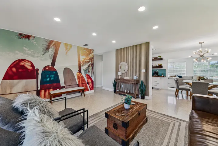 Recessed lighting, wood-finish slat wall accent, integrated built-in shelving, and a decorative chandelier